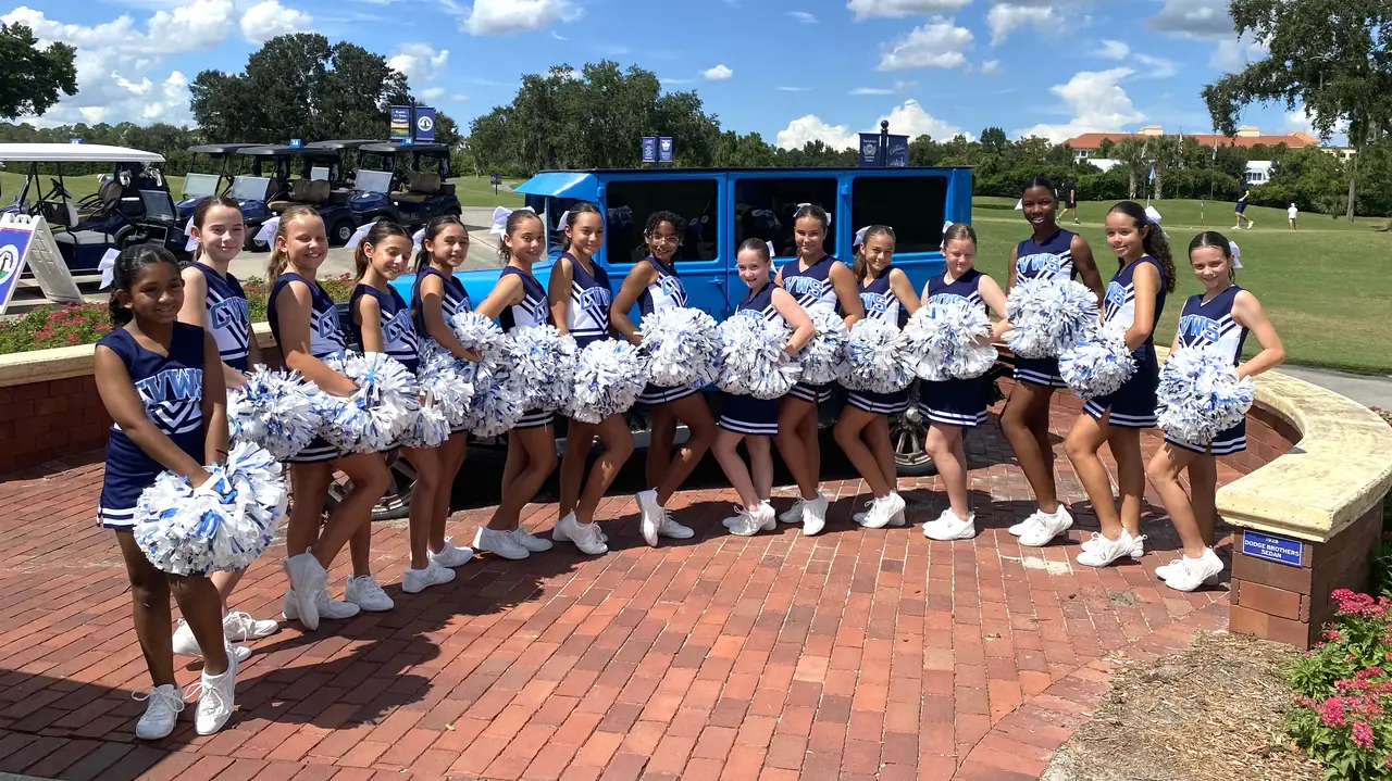 River Hawks cheerleaders with pom-poms on campus