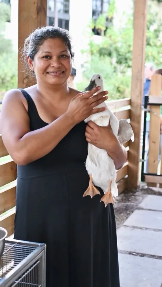 A team member holding a white duck at the festival animal encounter