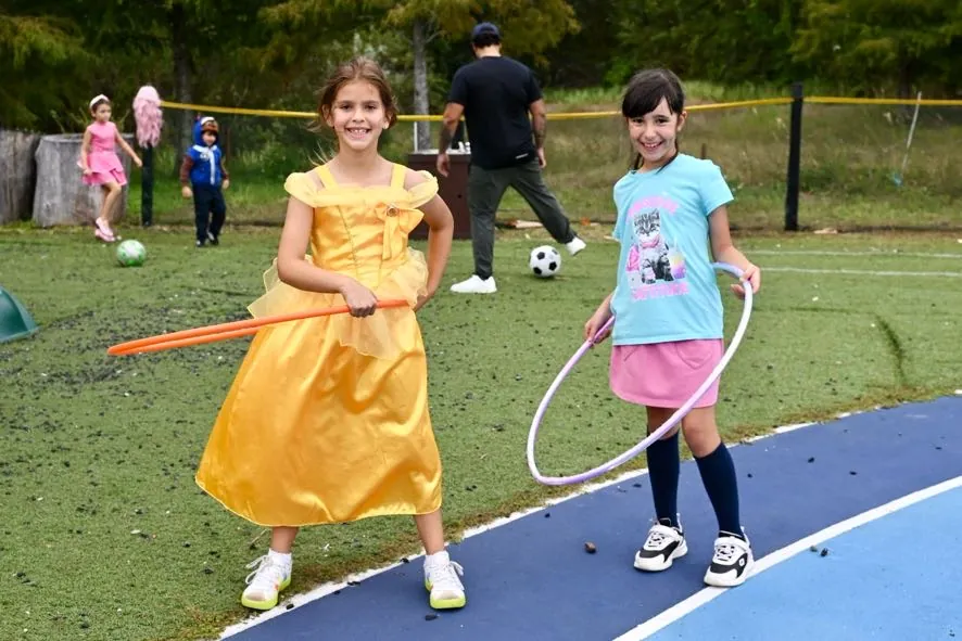 Two students in costume spinning hula hoops on the playing field