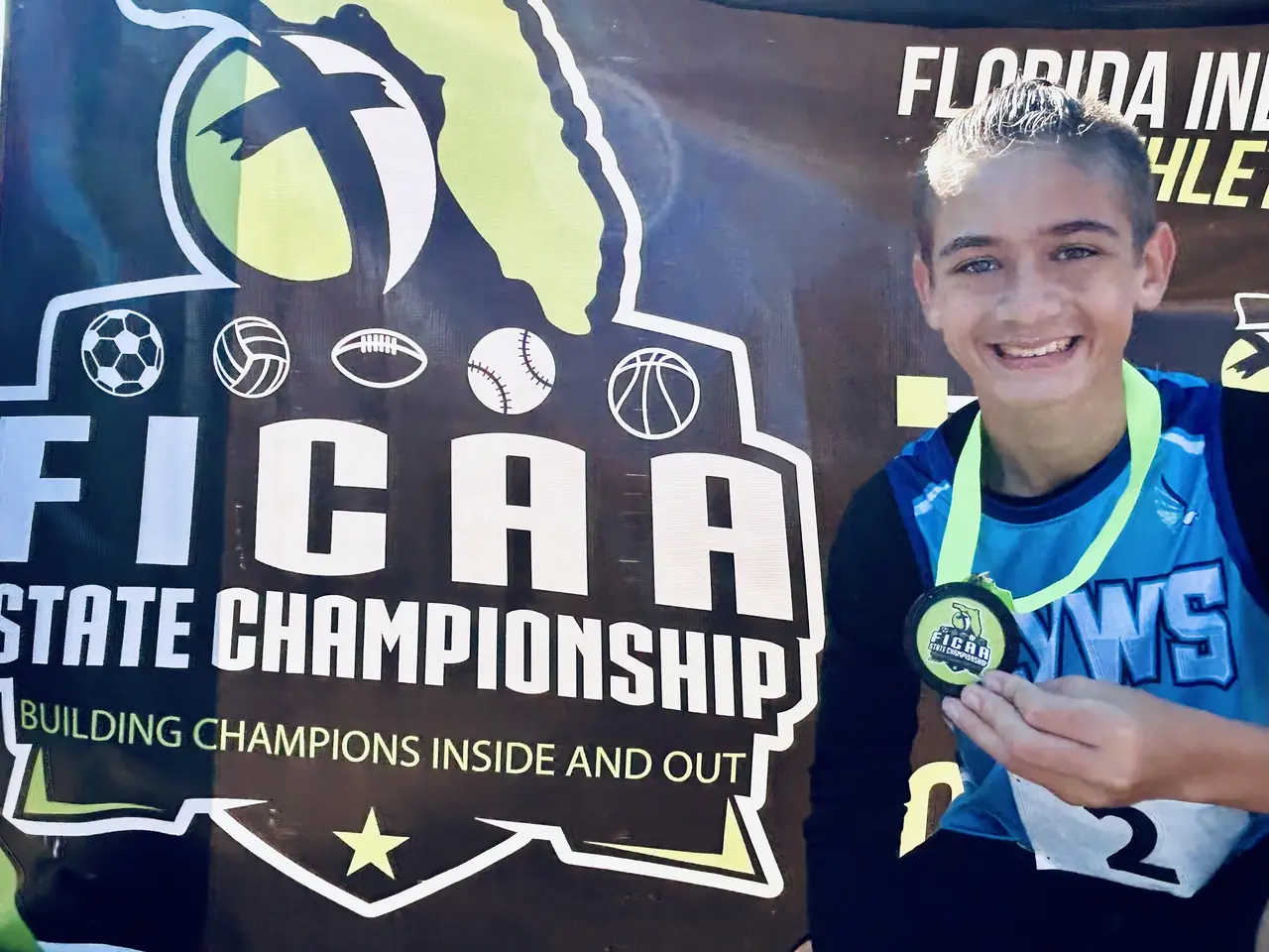 A River Hawks athlete with a medal at the FICAA State Championship