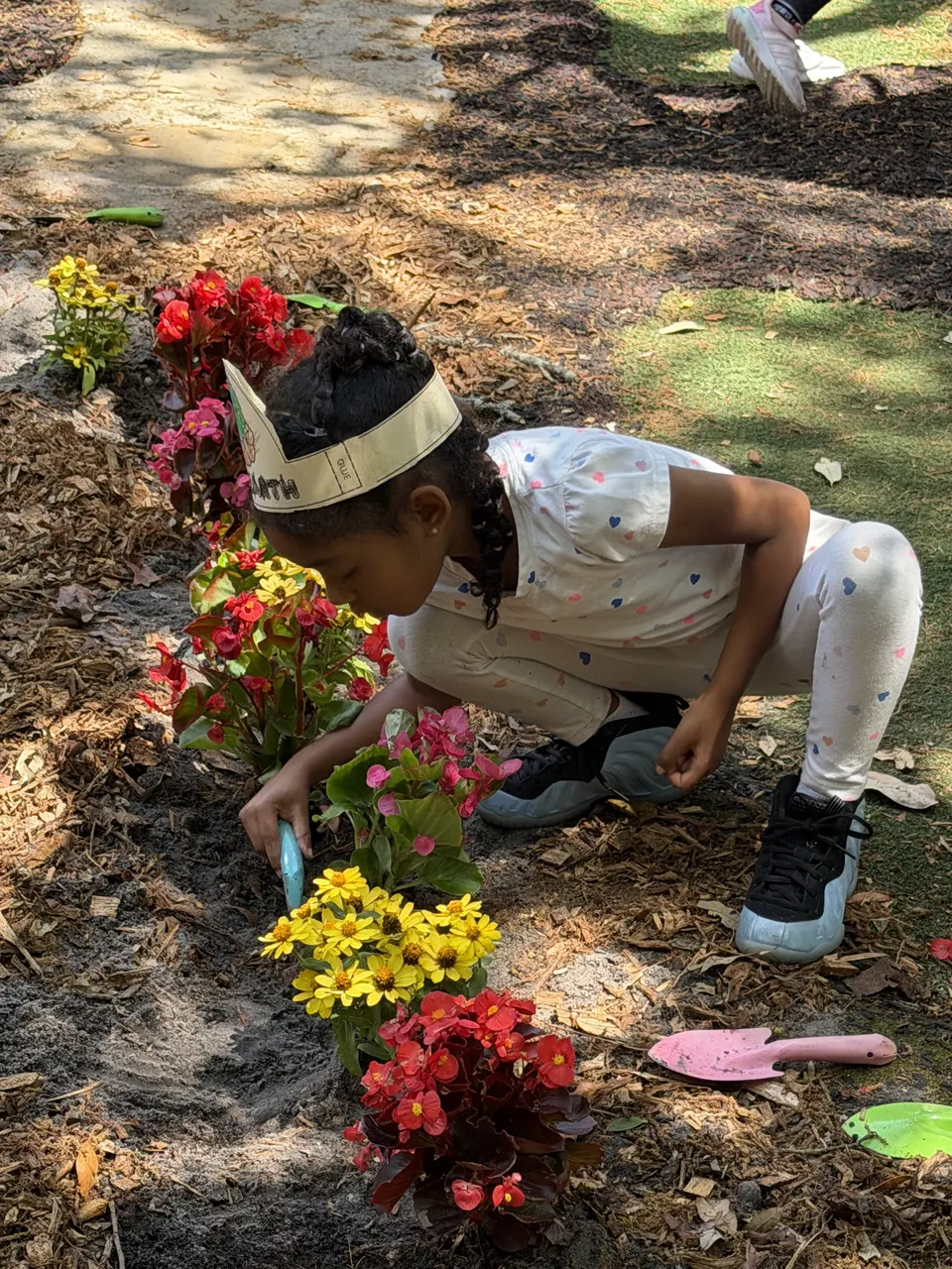 A student planting flowers in the garden