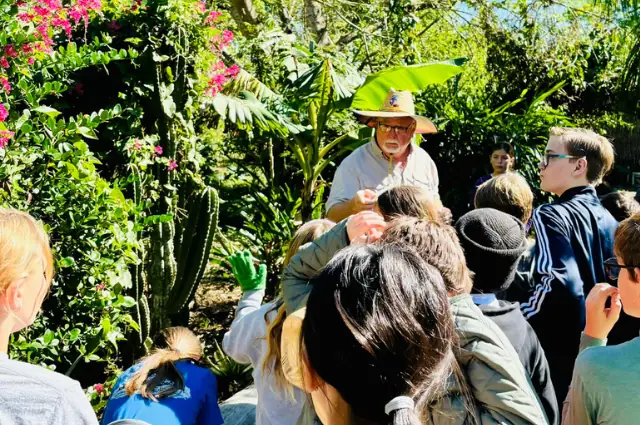 Students on a garden tour with a guide among tropical plants