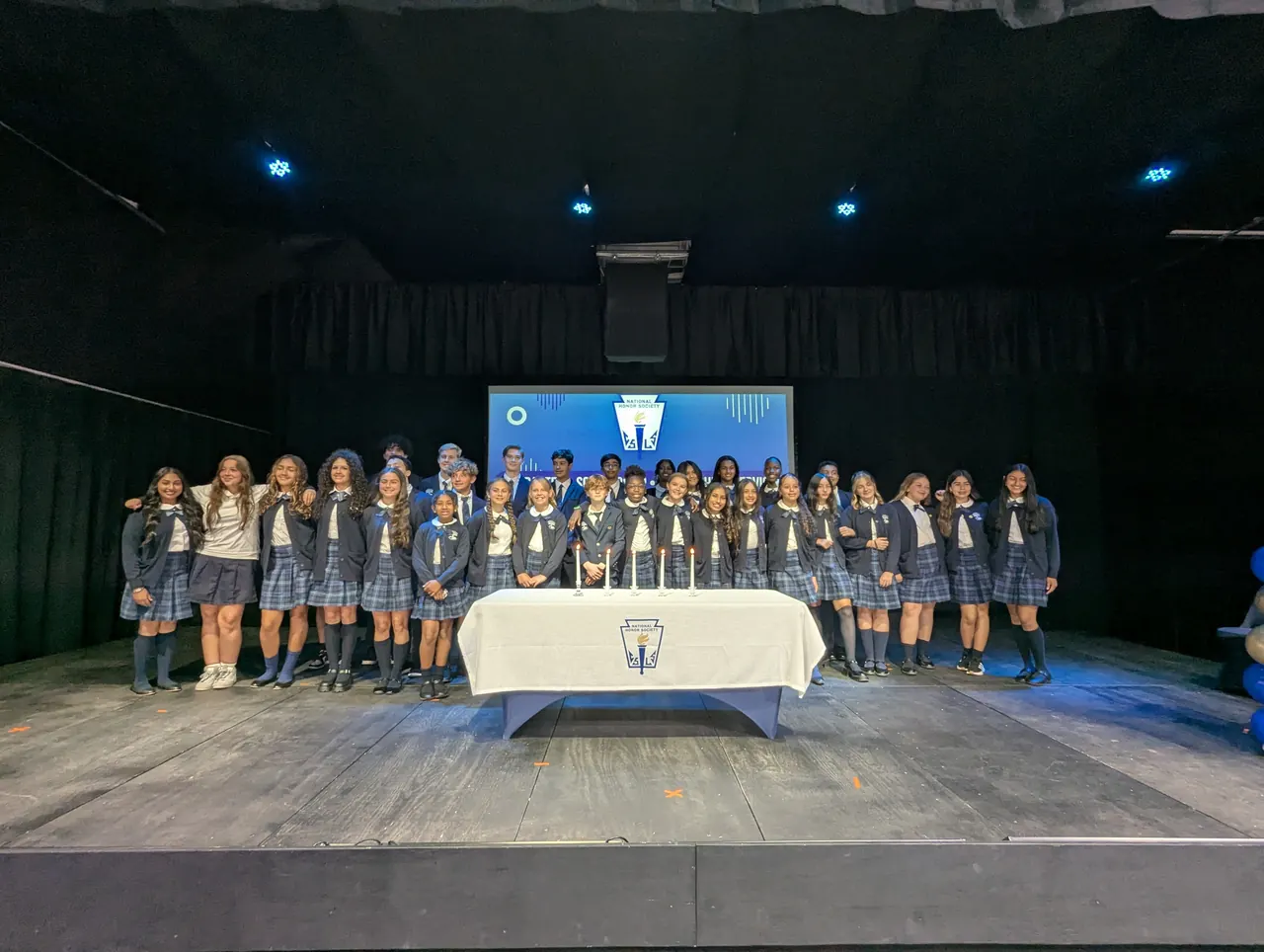 Students on stage at an honour society induction ceremony