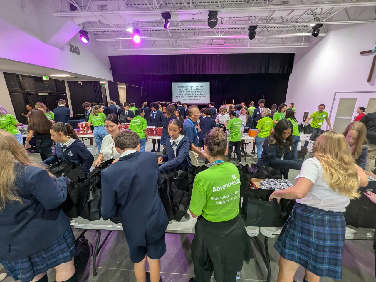 Students and volunteers working together at a meal-packing event
