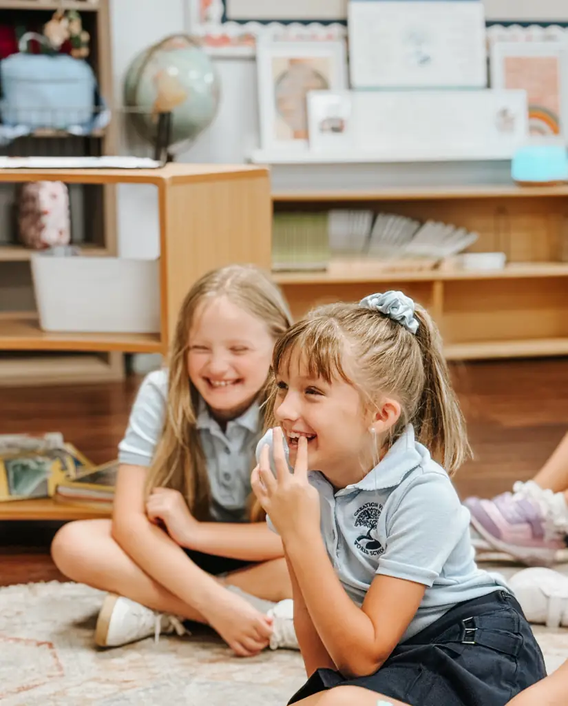 Two primary students laughing together during class