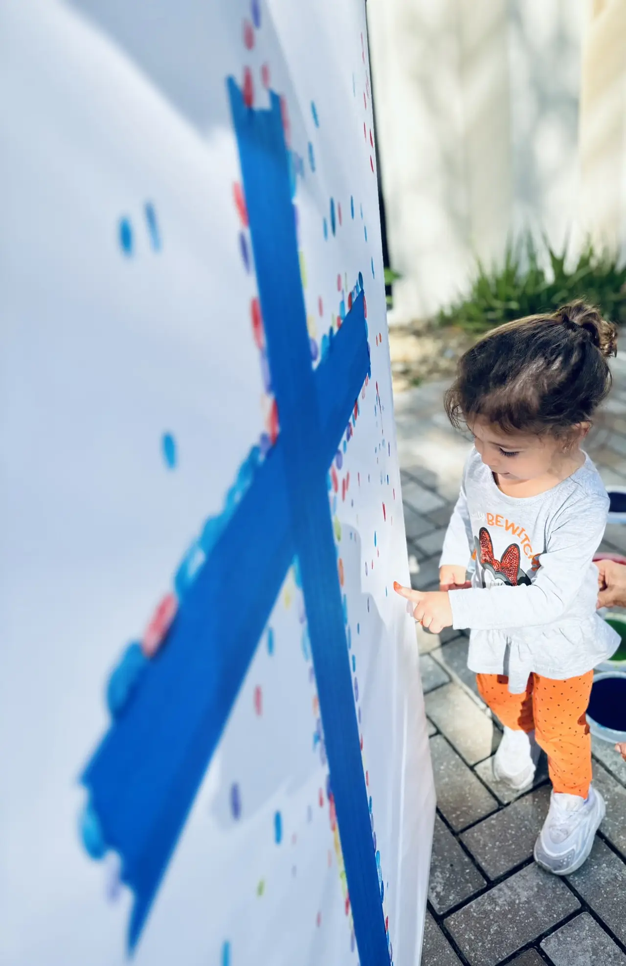 A young student painting a large canvas