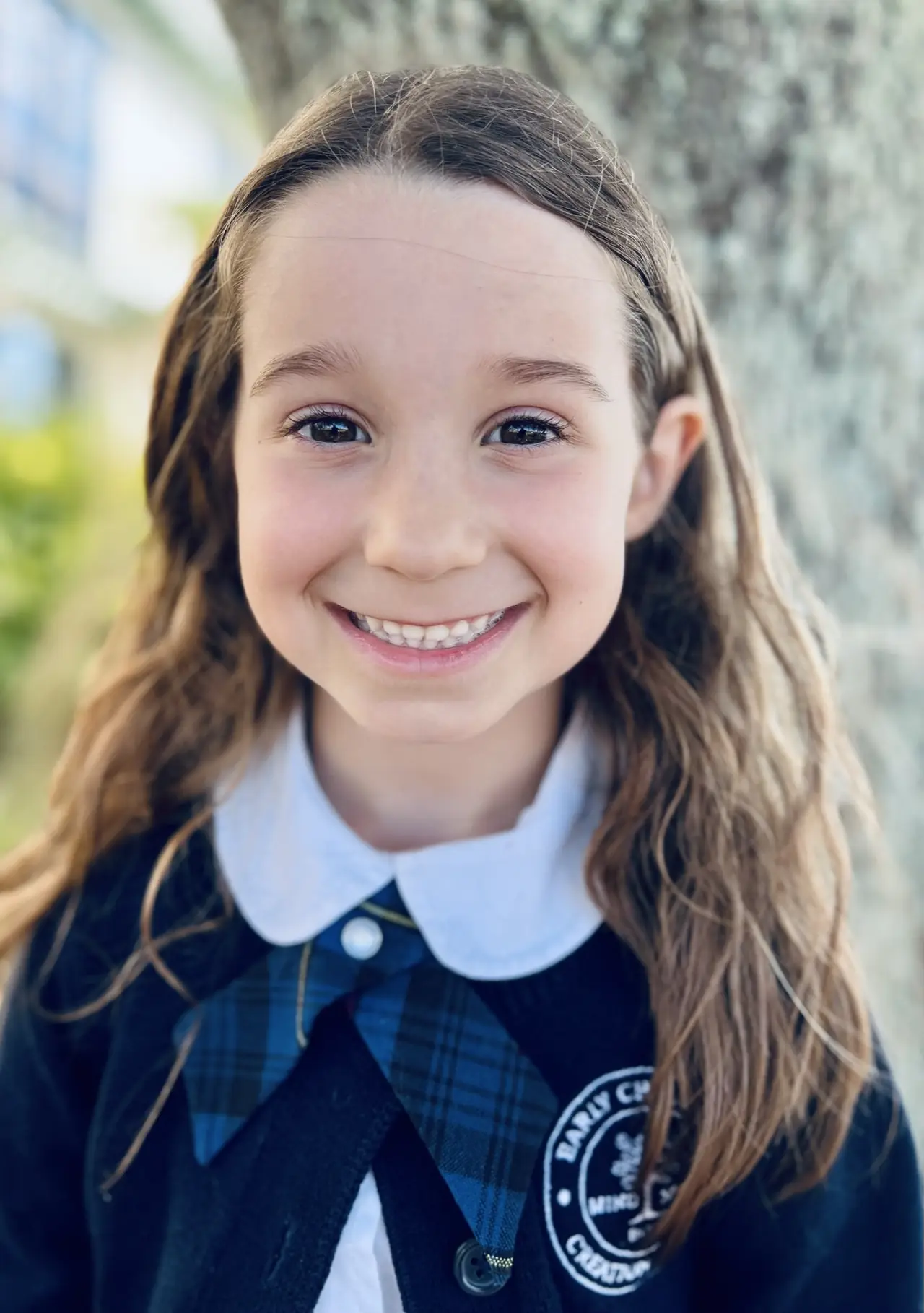 A smiling primary student in uniform