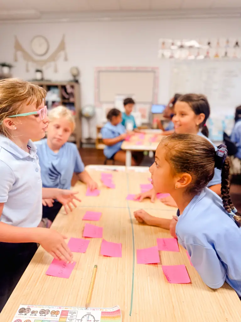 Primary students sorting word cards at a classroom table