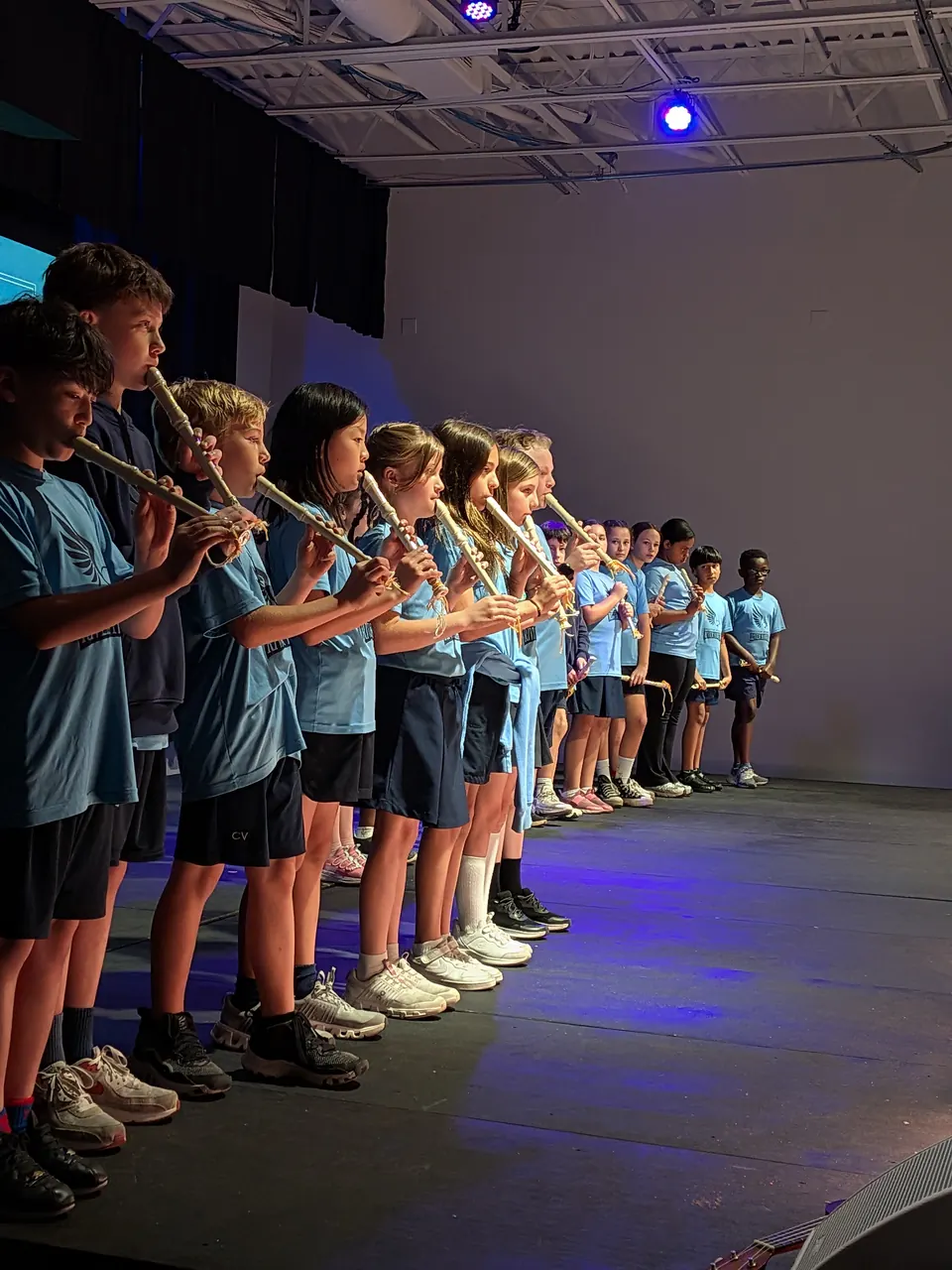 Primary students playing recorders on stage