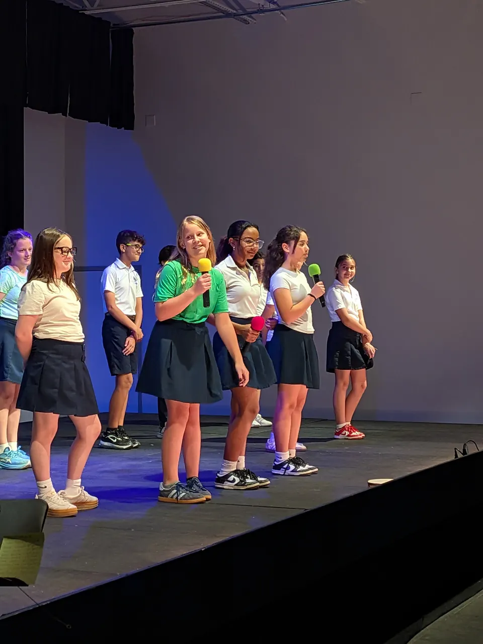 Students singing on stage at a school performance
